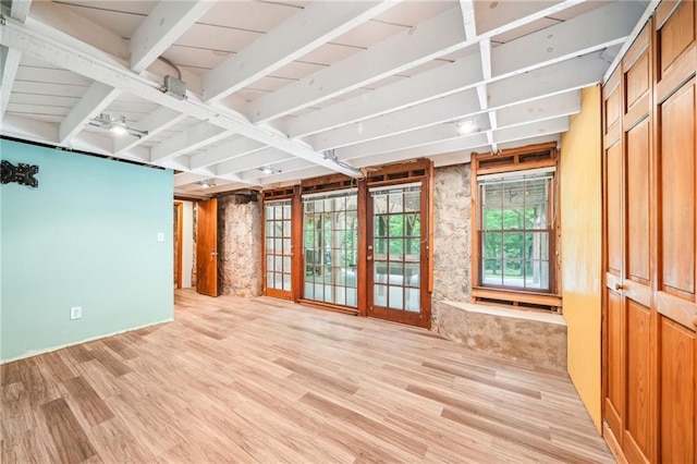 empty room with light wood finished floors, beamed ceiling, and ceiling fan