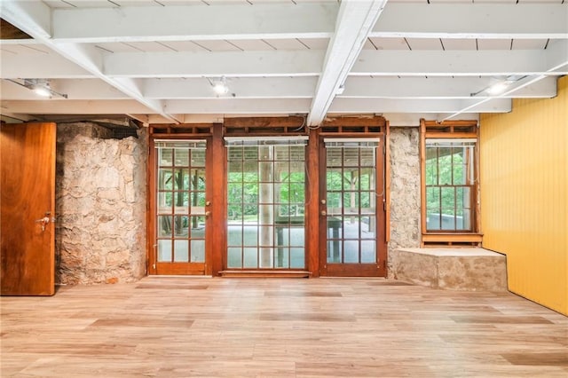 doorway to outside featuring wood finished floors and beam ceiling
