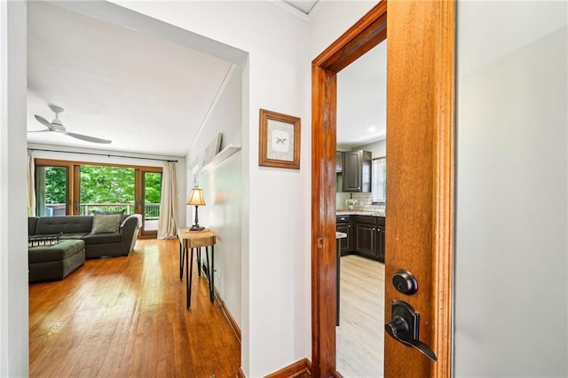 hallway featuring light wood-type flooring and baseboards