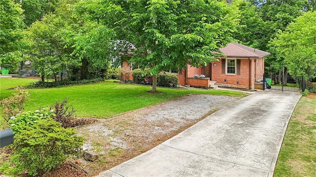 view of property hidden behind natural elements featuring concrete driveway, brick siding, and a gate