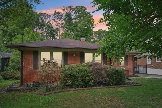 view of front facade featuring brick siding and a chimney