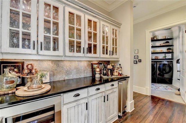 bar with washer and dryer, tasteful backsplash, dark wood-style floors, wine cooler, and crown molding