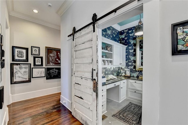 bathroom featuring wallpapered walls, baseboards, ornamental molding, wood finished floors, and vanity