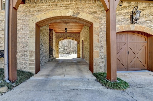 view of exterior entry with brick siding and a garage