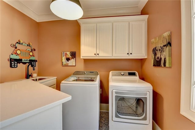 laundry room with washing machine and dryer, cabinet space, crown molding, and a sink