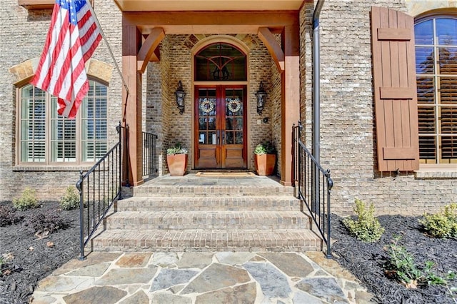 entrance to property featuring french doors and brick siding