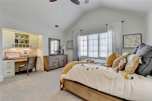 bedroom featuring a ceiling fan, visible vents, built in study area, lofted ceiling, and light carpet