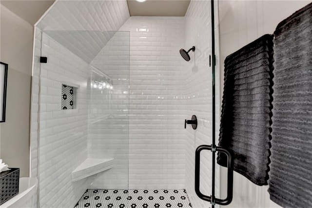 bathroom featuring vaulted ceiling and a stall shower