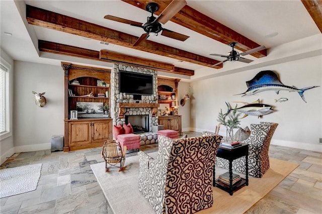 living room with a stone fireplace, beam ceiling, baseboards, and stone tile flooring