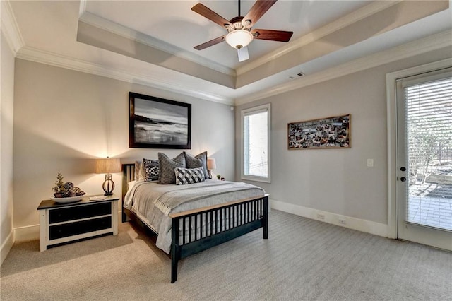 carpeted bedroom with a raised ceiling, access to outside, multiple windows, and crown molding