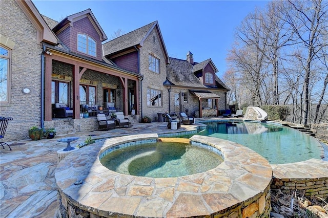 view of pool featuring a pool with connected hot tub, a water slide, and a patio