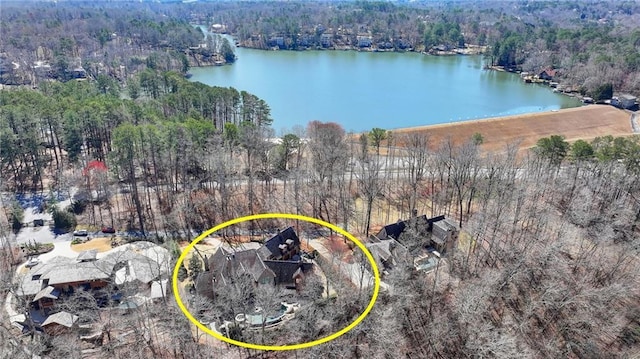 birds eye view of property featuring a forest view and a water view