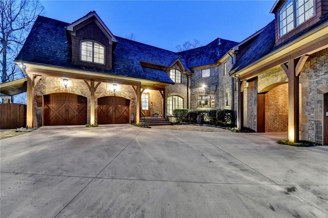 french provincial home with a garage and driveway