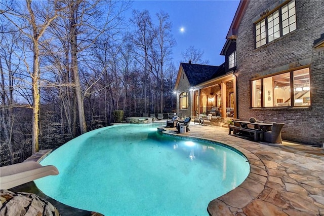 pool featuring a water slide and a patio