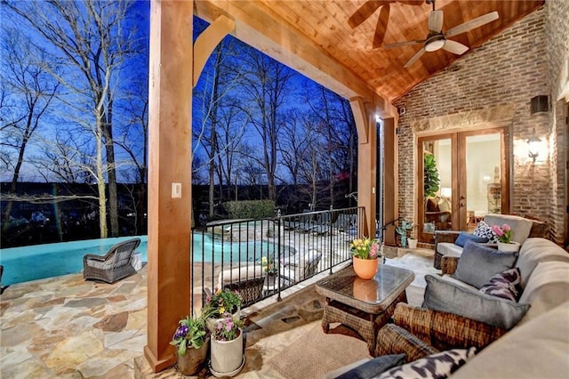 view of patio / terrace with fence, a ceiling fan, an outdoor pool, french doors, and outdoor lounge area