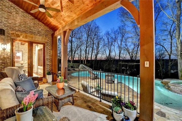 view of patio with outdoor lounge area, a ceiling fan, and a pool with connected hot tub