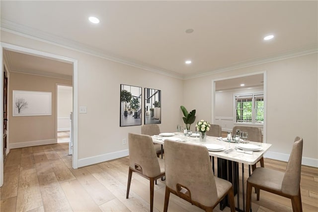 dining space with light wood finished floors, baseboards, and ornamental molding