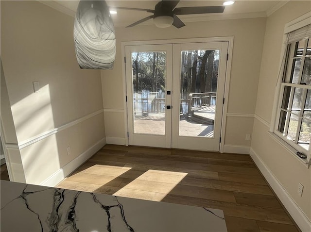 entryway featuring baseboards, hardwood / wood-style flooring, ceiling fan, crown molding, and french doors