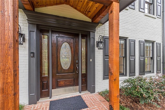 doorway to property featuring brick siding