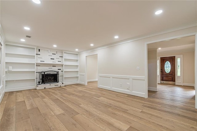 unfurnished living room featuring visible vents, crown molding, light wood-type flooring, a fireplace, and recessed lighting