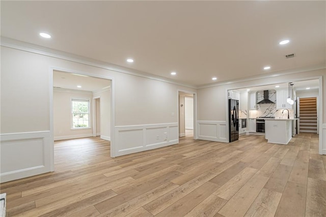 unfurnished living room featuring light wood-style floors, recessed lighting, visible vents, and crown molding