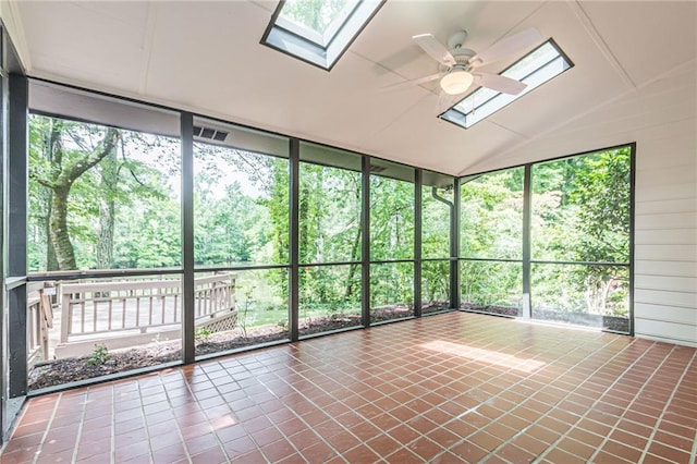 unfurnished sunroom with vaulted ceiling with skylight, plenty of natural light, and ceiling fan