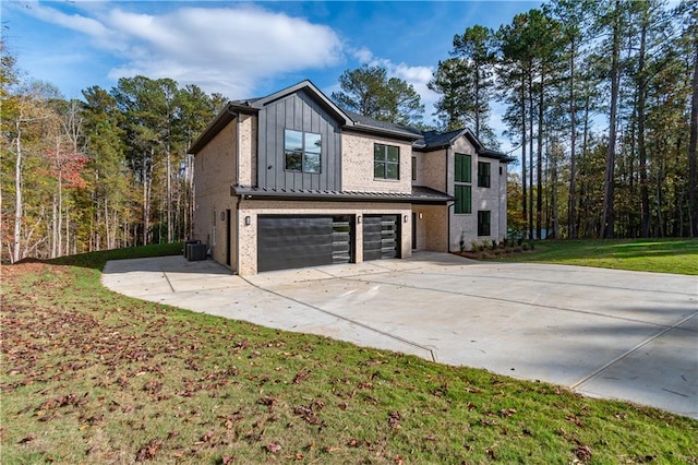 view of side of home featuring a garage, central AC unit, and a lawn