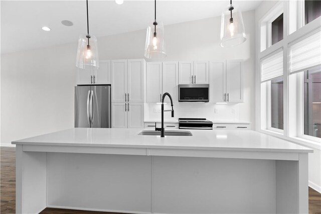 kitchen with lofted ceiling, stainless steel appliances, and a large island