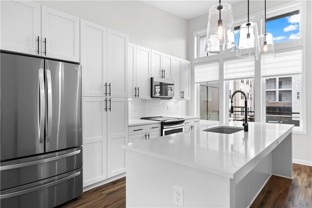 kitchen featuring white cabinets, a center island with sink, sink, dark hardwood / wood-style floors, and stainless steel appliances