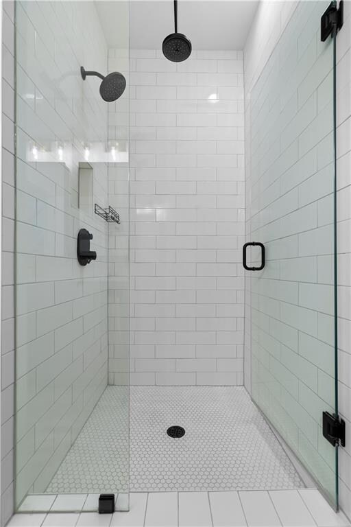 bathroom with tile patterned floors and a shower with shower door