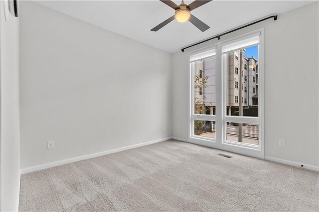 spare room featuring light carpet and ceiling fan