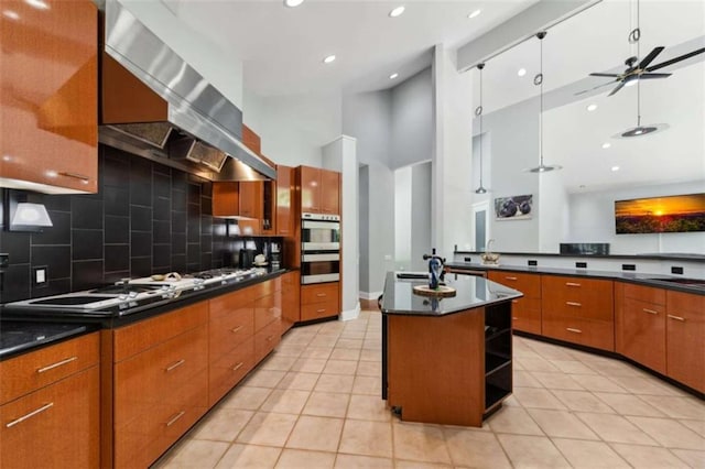 10323 Grassy Mountain Rd, Ellijay, GA 30540 - kitchen featuring white gas stovetop, dark countertops, wall chimney exhaust hood, backsplash, and a high ceiling