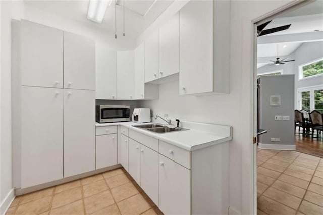 10323 Grassy Mountain Rd, Ellijay, GA 30540 - kitchen featuring stainless steel microwave, a ceiling fan, light countertops, light tile patterned flooring, and beamed ceiling