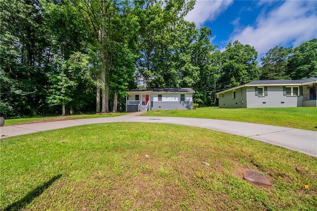 10150 Puckett St, Covington, GA 30014 - ranch-style house featuring a front yard, curved driveway, and view of wooded area