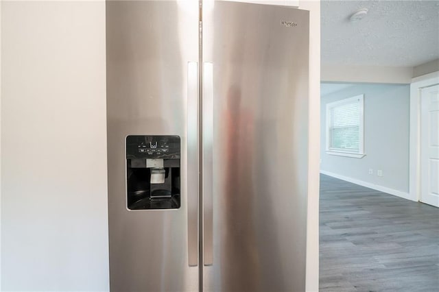 10150 Puckett St, Covington, GA 30014 - kitchen view of stainless steel fridge, wood finished floors, and a textured ceiling