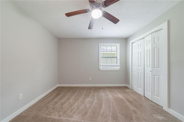 10150 Puckett St, Covington, GA 30014 - unfurnished bedroom featuring carpet, a textured ceiling, a closet, and a ceiling fan