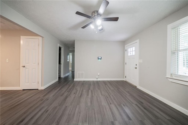 10150 Puckett St, Covington, GA 30014 - unfurnished living room with dark wood finished floors, ceiling fan, healthy amount of natural light, and a textured ceiling