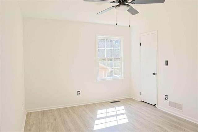 spare room with a ceiling fan, baseboards, visible vents, and light wood finished floors