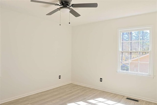 spare room with light wood-style floors, visible vents, and baseboards