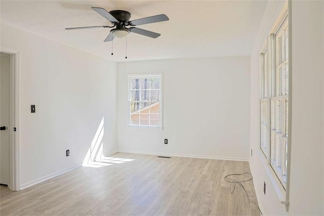 empty room with light wood-type flooring, baseboards, visible vents, and ceiling fan