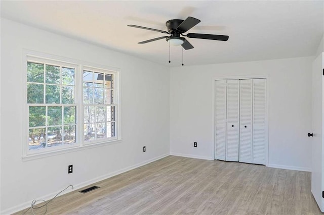 unfurnished bedroom with light wood finished floors, baseboards, multiple windows, and visible vents