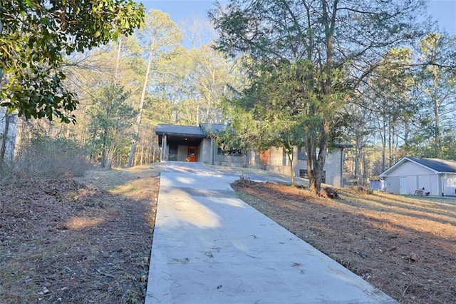 view of front facade featuring concrete driveway and a carport