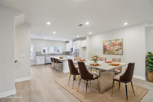 dining room featuring sink and light hardwood / wood-style flooring