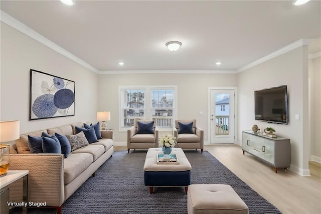 living room with ornamental molding and light hardwood / wood-style flooring