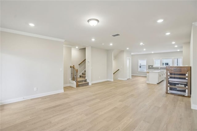 living room with ornamental molding and light wood-type flooring