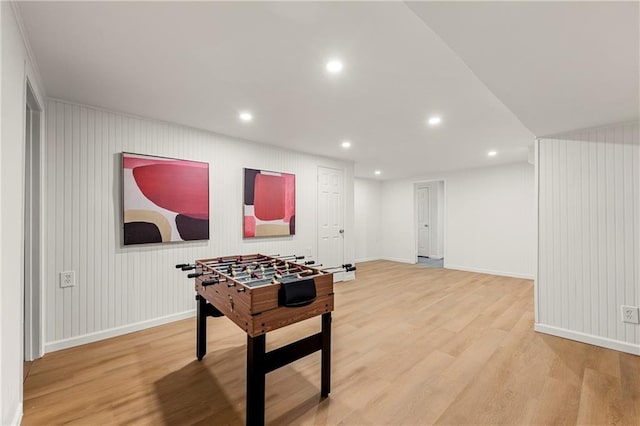 rec room with wood walls and hardwood / wood-style flooring