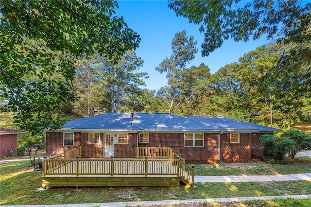 view of front facade featuring a deck and a front lawn