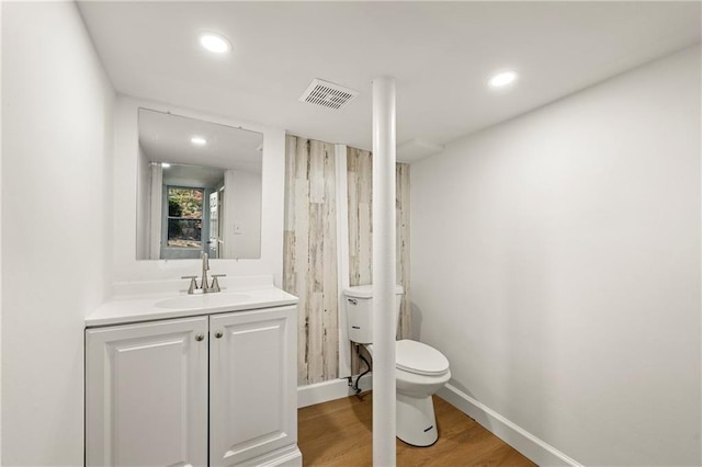 bathroom with hardwood / wood-style floors, vanity, and toilet