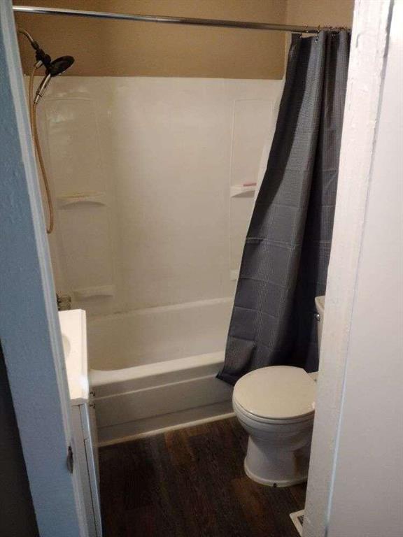 1005 Ashby Ter, Atlanta, GA 30314 - bathroom with wood-type flooring, toilet, and shower / tub combo with curtain