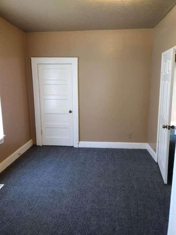 1005 Ashby Ter, Atlanta, GA 30314 - empty room featuring dark colored carpet and a textured ceiling